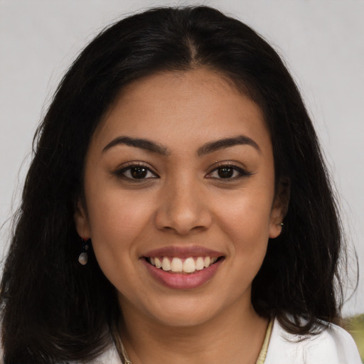 Joyful latino young-adult female with long  brown hair and brown eyes