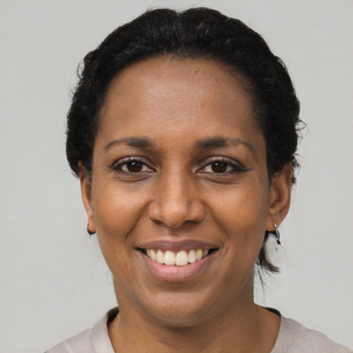 Joyful black adult female with short  black hair and brown eyes