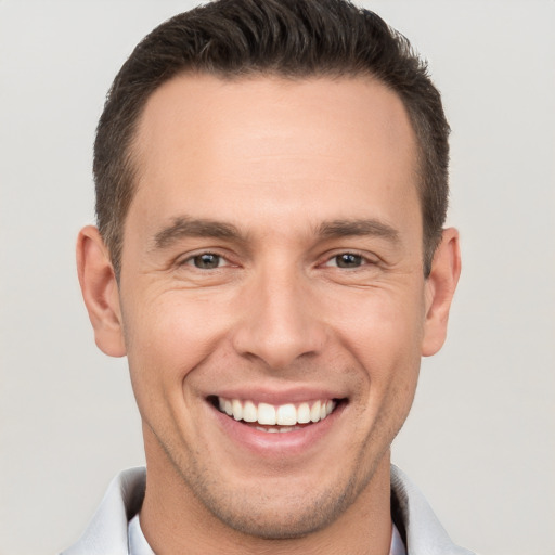 Joyful white young-adult male with short  brown hair and brown eyes