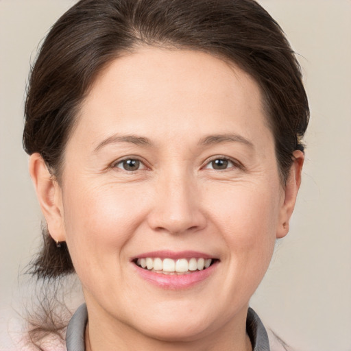 Joyful white adult female with medium  brown hair and brown eyes