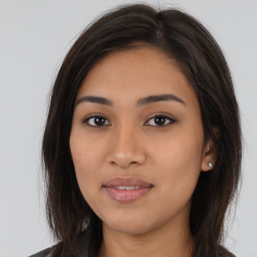 Joyful latino young-adult female with long  brown hair and brown eyes