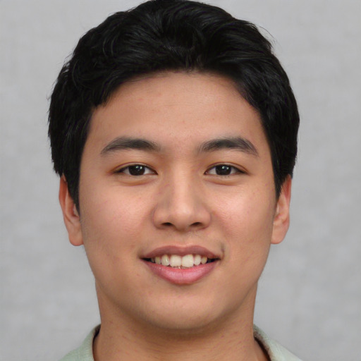 Joyful asian young-adult male with short  black hair and brown eyes