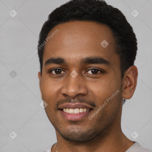 Joyful black young-adult male with short  brown hair and brown eyes