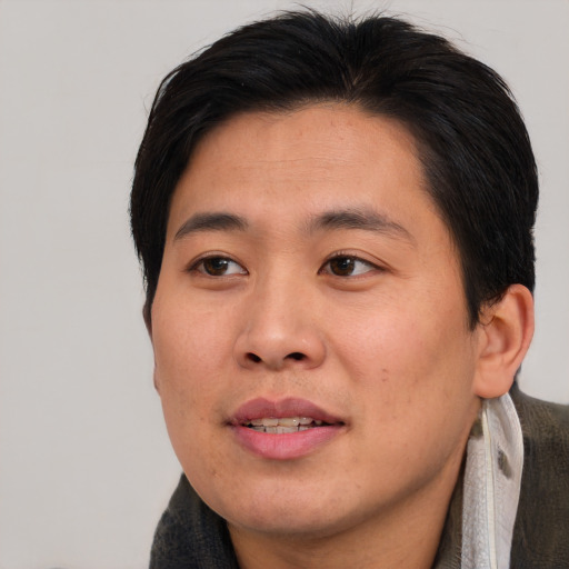 Joyful asian young-adult male with short  brown hair and brown eyes