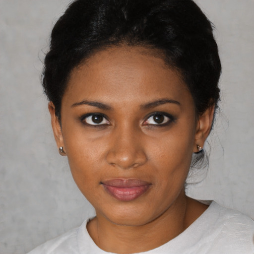 Joyful black young-adult female with short  black hair and brown eyes