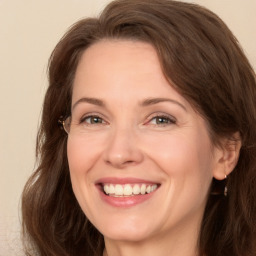 Joyful white adult female with long  brown hair and brown eyes