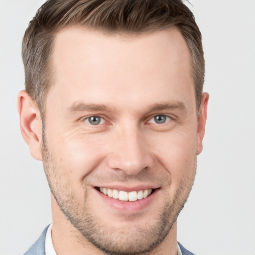 Joyful white young-adult male with short  brown hair and grey eyes