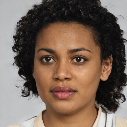 Joyful black young-adult female with medium  brown hair and brown eyes