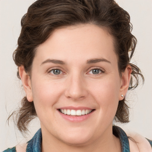 Joyful white young-adult female with medium  brown hair and green eyes