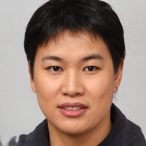 Joyful asian young-adult male with short  brown hair and brown eyes