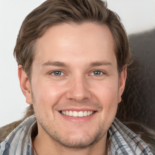 Joyful white young-adult male with short  brown hair and grey eyes