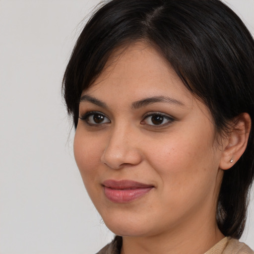 Joyful latino young-adult female with medium  brown hair and brown eyes