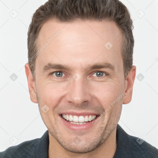 Joyful white adult male with short  brown hair and grey eyes