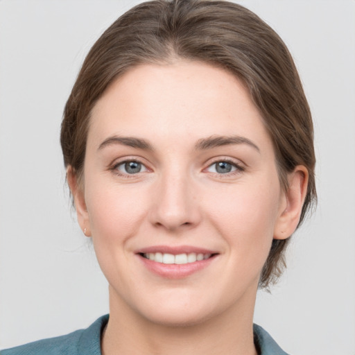 Joyful white young-adult female with medium  brown hair and grey eyes