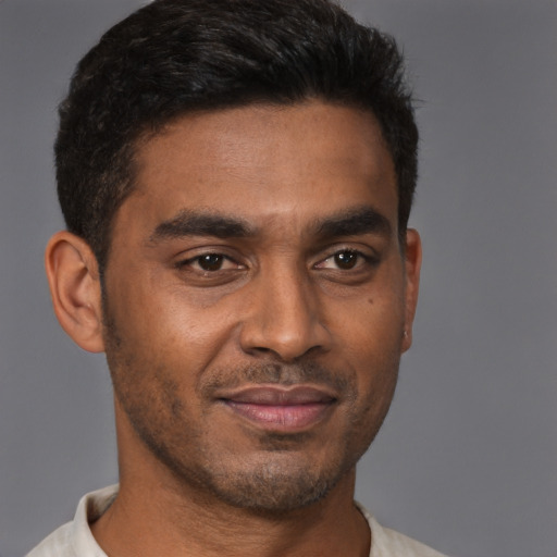 Joyful latino young-adult male with short  brown hair and brown eyes