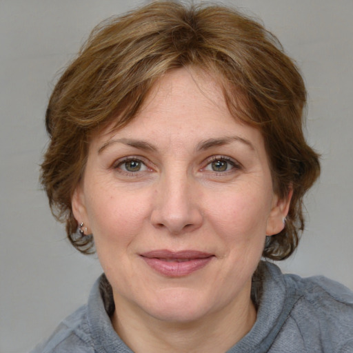 Joyful white adult female with medium  brown hair and grey eyes