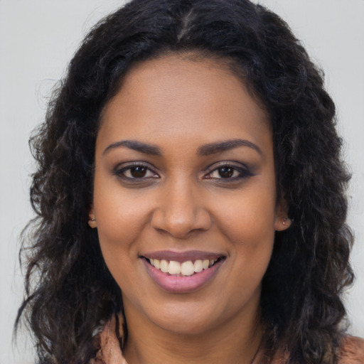 Joyful black young-adult female with long  brown hair and brown eyes