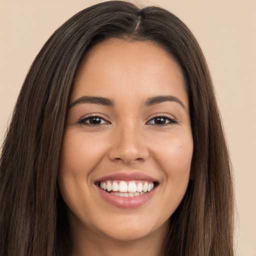 Joyful white young-adult female with long  brown hair and brown eyes