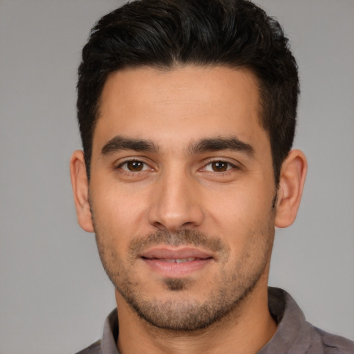 Joyful white young-adult male with short  black hair and brown eyes