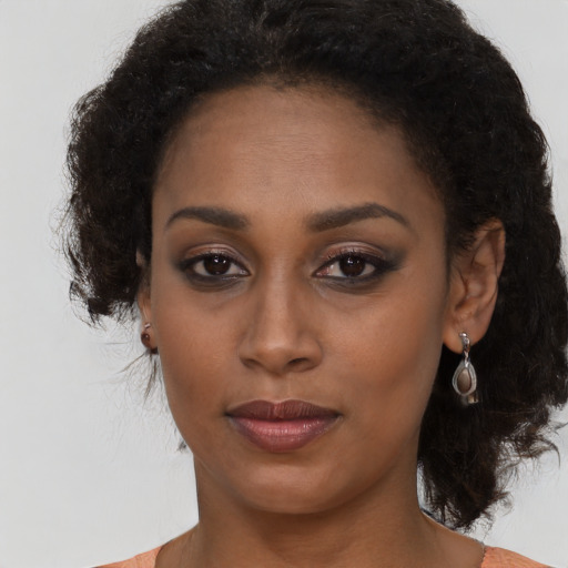 Joyful black young-adult female with medium  brown hair and brown eyes