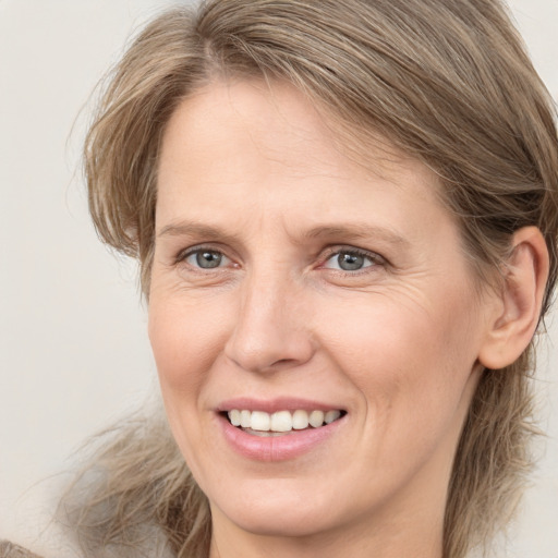 Joyful white adult female with medium  brown hair and grey eyes