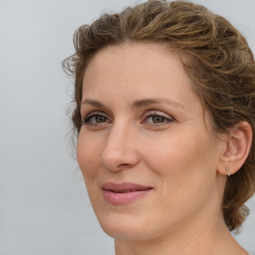 Joyful white young-adult female with medium  brown hair and green eyes