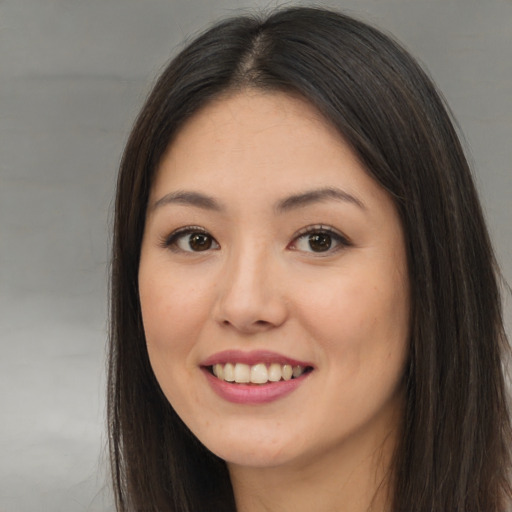 Joyful asian young-adult female with long  brown hair and brown eyes