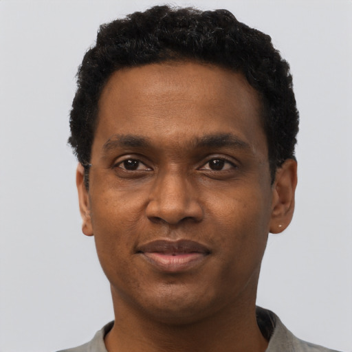 Joyful black adult male with short  black hair and brown eyes