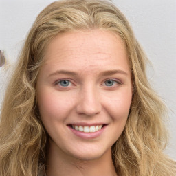 Joyful white young-adult female with long  brown hair and blue eyes