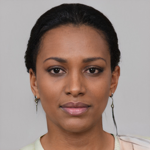Joyful black young-adult female with short  black hair and brown eyes