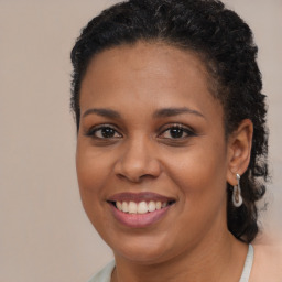 Joyful black young-adult female with long  brown hair and brown eyes