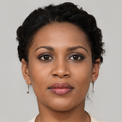 Joyful black young-adult female with short  brown hair and brown eyes