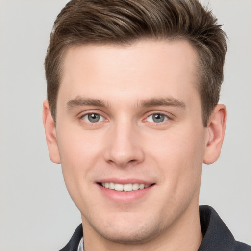 Joyful white young-adult male with short  brown hair and grey eyes