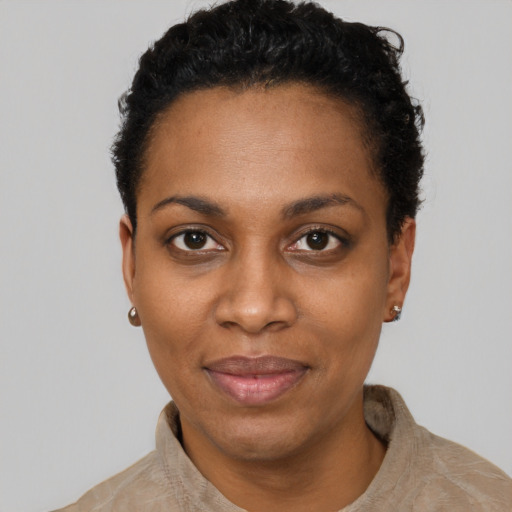 Joyful black young-adult female with short  black hair and brown eyes
