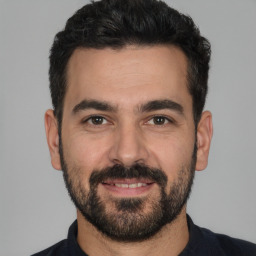 Joyful white young-adult male with short  black hair and brown eyes