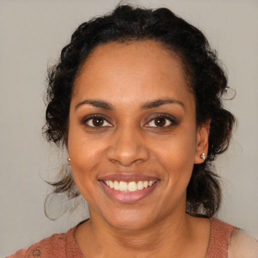 Joyful black young-adult female with medium  brown hair and brown eyes
