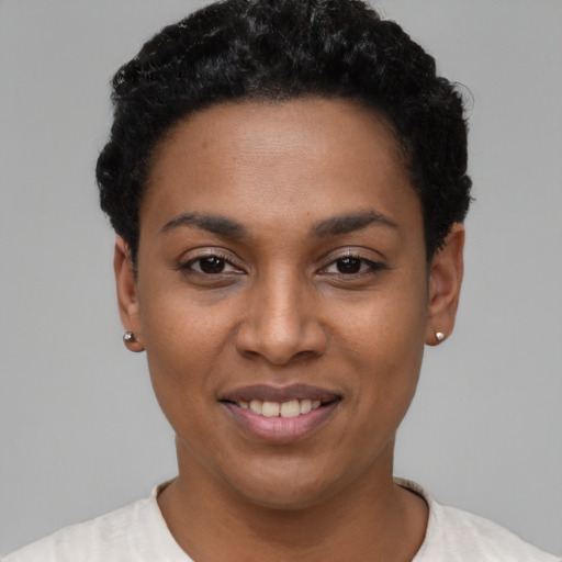 Joyful black young-adult female with short  black hair and brown eyes