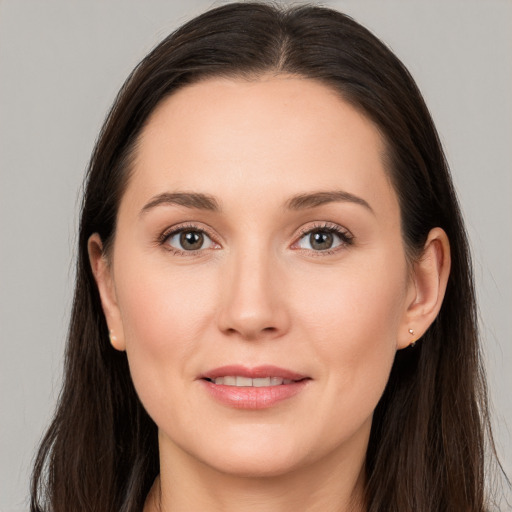 Joyful white young-adult female with long  brown hair and brown eyes