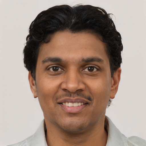 Joyful black young-adult male with short  black hair and brown eyes