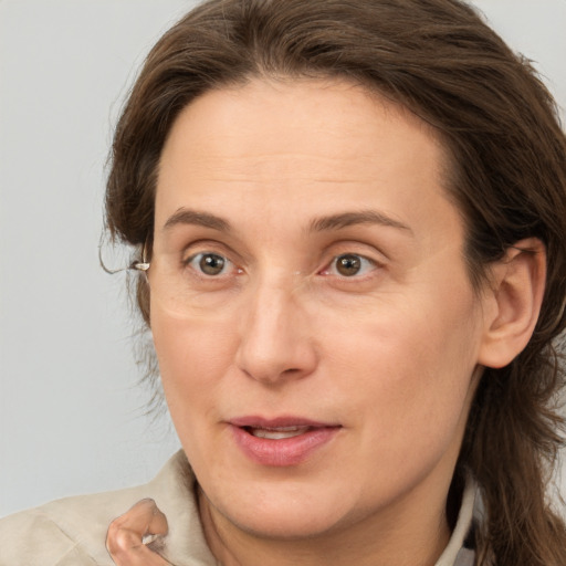 Joyful white adult female with medium  brown hair and brown eyes