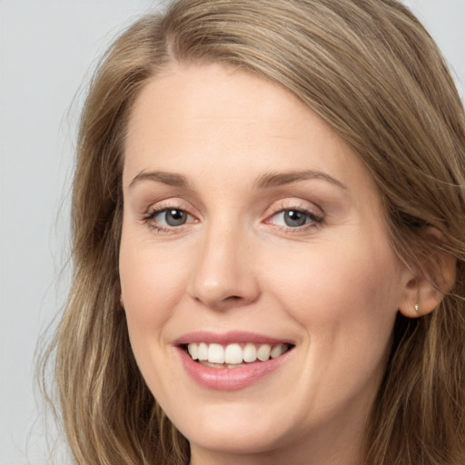 Joyful white young-adult female with long  brown hair and grey eyes