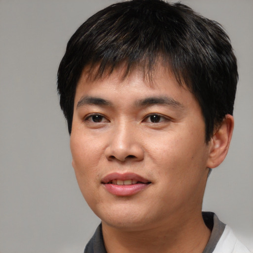 Joyful asian young-adult male with short  brown hair and brown eyes