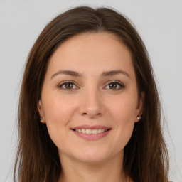 Joyful white young-adult female with long  brown hair and brown eyes