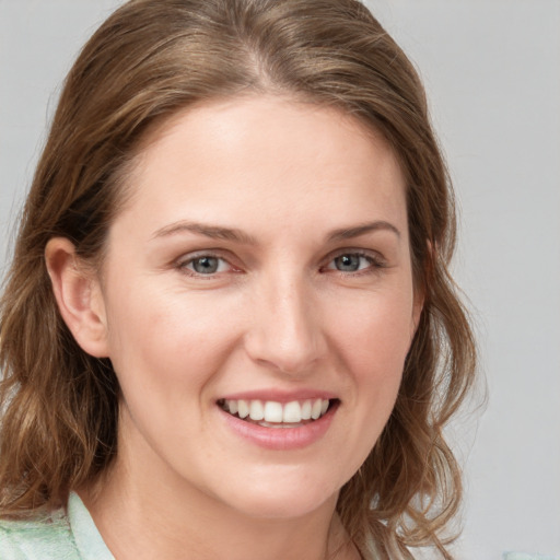 Joyful white young-adult female with medium  brown hair and blue eyes