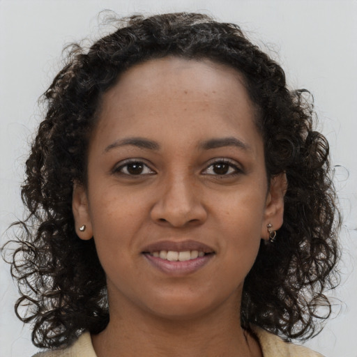 Joyful black young-adult female with long  brown hair and brown eyes