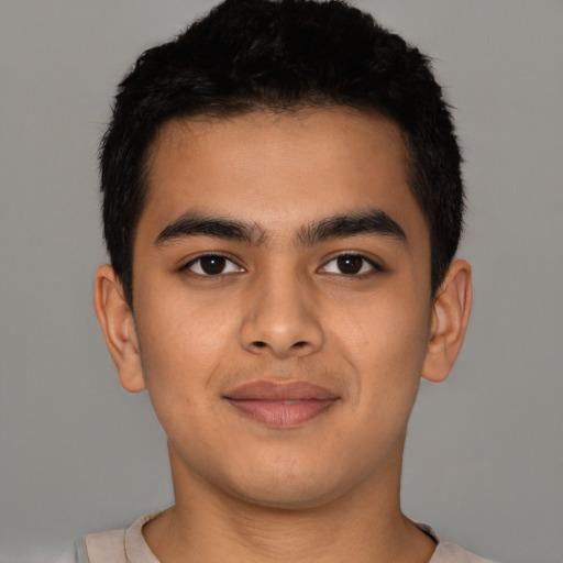 Joyful latino young-adult male with short  brown hair and brown eyes