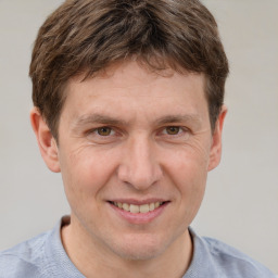 Joyful white adult male with short  brown hair and grey eyes