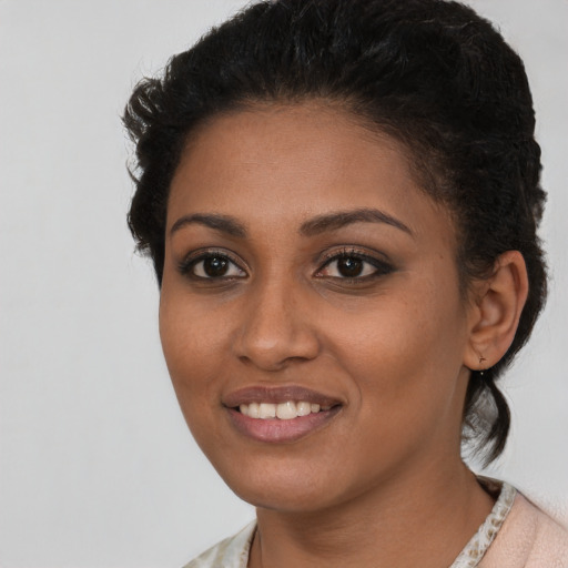 Joyful black young-adult female with short  brown hair and brown eyes
