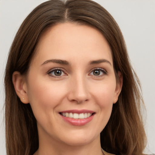 Joyful white young-adult female with long  brown hair and brown eyes