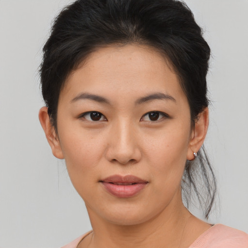 Joyful asian young-adult female with short  brown hair and brown eyes